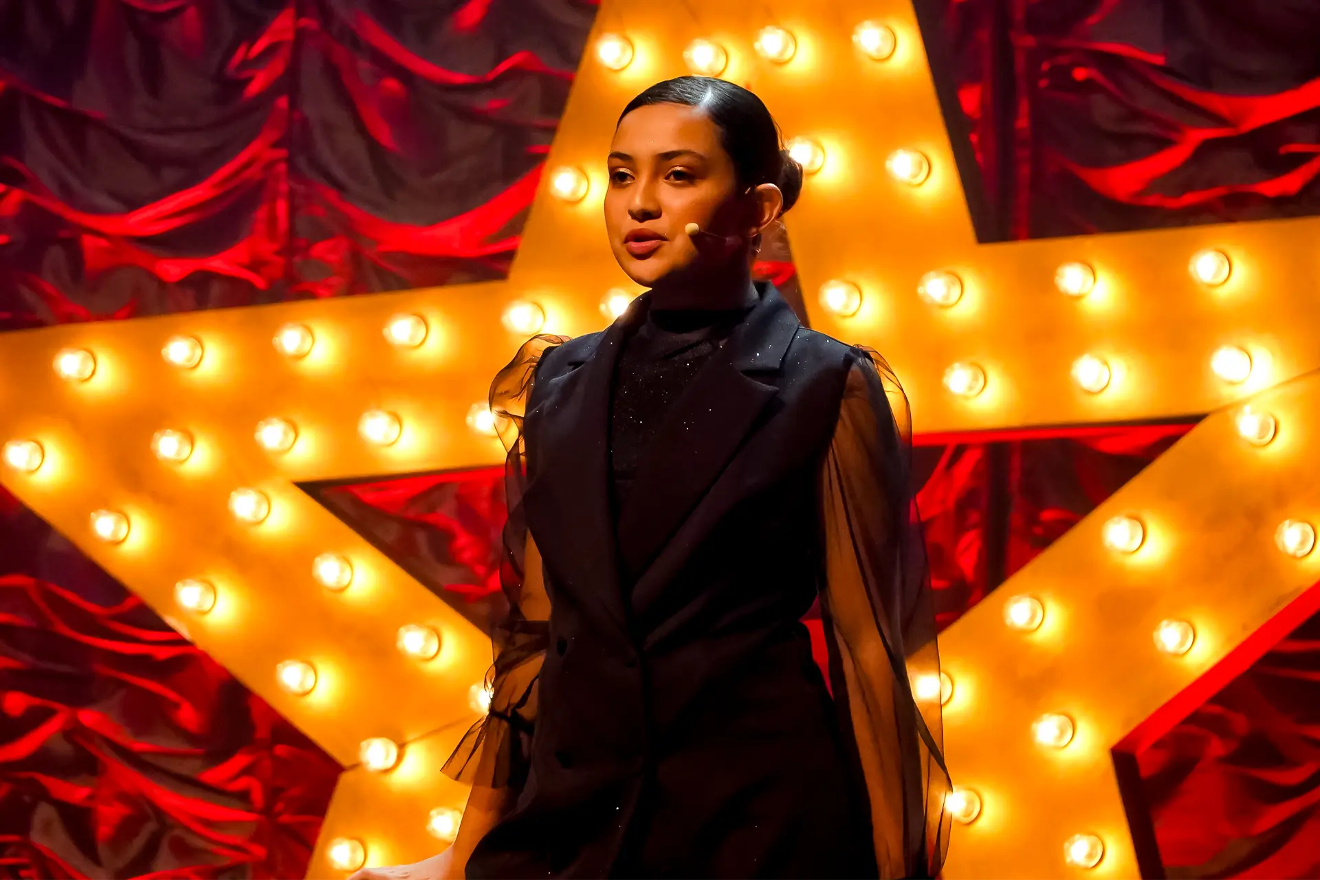 Aluna em solo diante da estrela luminosa no Spotlight